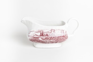 White ceramic sauce pot with red castle motif against a white background