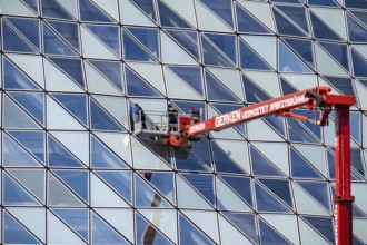 Building cleaners cleaning window panes, cleaning a facade, lorry working platform of the German