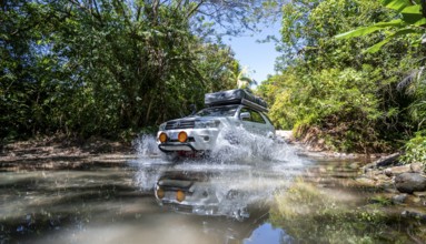 4x4 car drives through a river, water crossing with the off-road car, Costa Rica, Central America