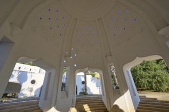 Interior of a dome-shaped structure with blue light patterns and step-like elements, illuminated by