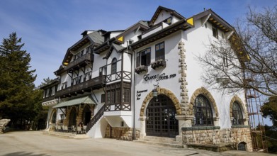 Historic white hotel with half-timbering, balconies and stone arches on a sunny day, Elafos Hotel,