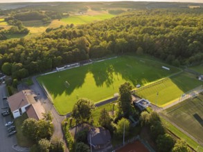 Green sports field in the middle of lush nature at sunset, taken from above, Gechingen, Black