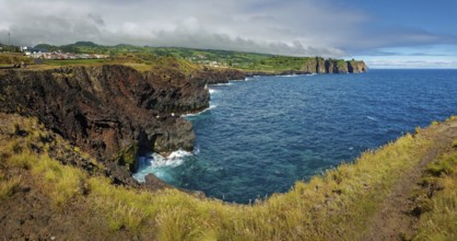 Panorama of a rocky coastline with a view of the vast blue sea and steep cliffs, Capelas, Sao