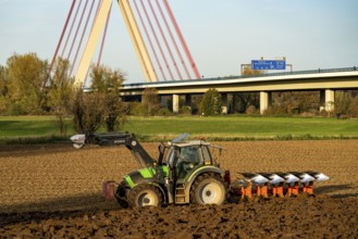 Farmer ploughing a field, tractor with plough, near Neuss, Fleher motorway bridge, A46, North