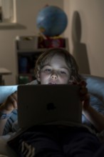 A boy plays computer games on a tablet PC