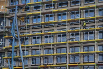 Large construction site, scaffolded shell of an office building complex, air hoses for building