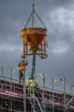 Concrete work, at dusk, on a large construction site building a residential and commercial complex,