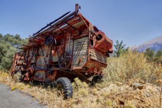 Rusty combine harvester in rural area on a road in summer weather, wrecked vehicle, Crete, Greek