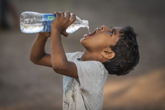 Boy drinking water from a plastic bottle, Fort Cochin, Kochi, Kerala, South India, India, Asia