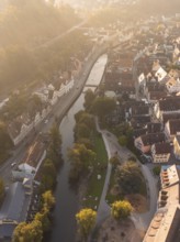 Aerial view of a town with a river and residential buildings, illuminated by the sunset, Calw,