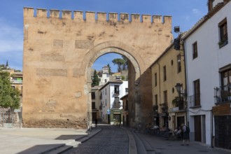 Old city wall with round arch in a sunny old town, Granada