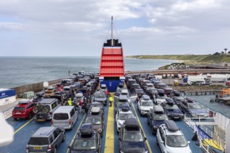 Ferry fully loaded with cars on the sea, in the background the coast and cloudy sky, Rosslare