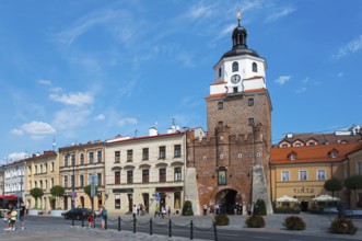 Historic Old Town with an impressive brick tower under a clear blue sky, Krakow Gate, Brama