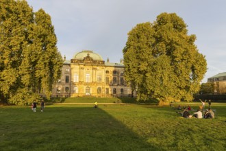 Japanese palace in the evening light, Elbe side with people on the meadow, Dresden, Saxony,