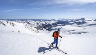 Ski tourers in front of a mountain panorama, snow-covered mountain landscape with glacier in