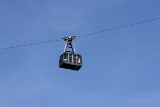 A cable car cabin floats high in the clear blue sky, Tegelbergbahn, Schwangau, Ostallgäu, Allgäu,