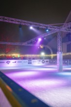 Vacant ice rink in a night-time atmosphere with purple lighting and modern architecture, Christmas