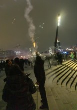 Person launches firework rocket from his hand, New Year's Eve 2025 on the Elbe promenade in