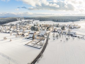 Snow-covered village with streets and buildings under a cloudy sky, Oberreichenbach, Black Forest,