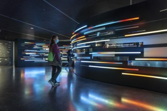 Visitor with mask in the exhibition in the interior of the Museum for Future Issues Futurium in