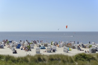 View of the beach with beach chairs, kite surfers on the North Sea, blue sky, Norddeich, Lower