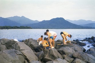 Emigrants from Europe, men and children fishing on rocks on the coast, Sierra Leone, West Africa