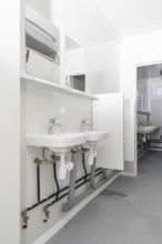 Bright bathroom with two washbasins and minimalist mirrors, refugee accommodation Beermiß,