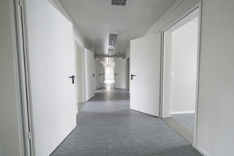 Modern, minimalist hallway with open white doors, Beermiß refugee accommodation, Calmbach, Black