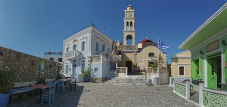 Sunny Plati Square in the picturesque village of Olymbos with colourful buildings and the church of