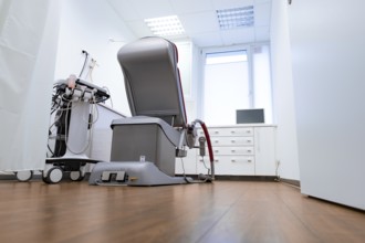 Modern medical treatment room with one chair and equipment, bright atmosphere, Urology, Germany,