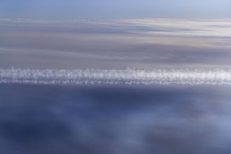 View of the Persian Gulf from the aeroplane window. Sun and clouds over the sea. Aeroplane above