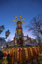 Large Christmas pyramid at the Christmas market at dusk, behind the historic town hall, Lüneburg,