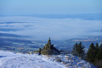 Winter landscape with snow-covered hill and aviation monument, cloudy sky and wide view,