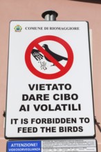 Posted bilingual Italian and English It is Forbidden to Feed The Birds pictogram sign, Riomaggiore,