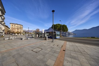 Bus stop, public bus, hilly landscape, blue sky with veil clouds, Lake Lugano, street Riva Vincenzo