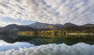 Autumnal mountain landscape with mountain peaks Herzogstand and Heimgarten, reflection in Lake