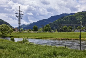 River Kinzig, bank with meadow and trees, electricity pylon, transformer station, hilly landscape