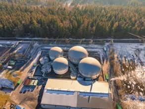 Aerial view of an industrial tank farm surrounded by snow-covered forest, Neubulach, Black Forest,