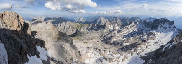 Summit cross on the summit of the Zugspitze, view of mountain panorama with Zugspitzplatt with snow