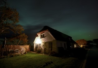 Northern Lights (Aurora borrealis) over a thatched roof house, Junkersmitteldeich, Pellworm Island,