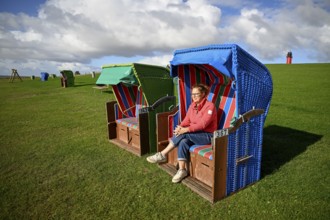 Woman in a beach chair on the island of Pellworm, Wadden Sea National Park, North Frisia, Germany,