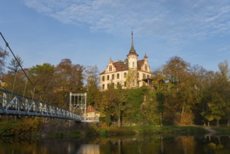 Castle on a wooded hill with adjoining bridge and river in autumn, Gattersburg Castle, suspension