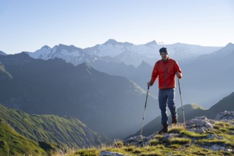 Hiker enjoying the mountain panorama in the morning, Venediger group, behind Dreiherrenkopf,