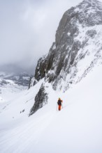 Ski tourer on a steep mountain slope, Snowy mountain landscape, Bernese Alps, Bernese Oberland,