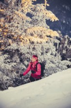 A woman's ski tour at sunrise on the Tegelberg in the Allgäu in the Ammergebirge, Bavaria, Germany,