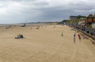 People holidaymakers beach in overcast weather, South Beach, Kirkley, Lowestoft, Suffolk, England,