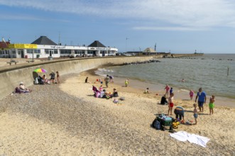 Families enjoying sunny summer weather on South Pier beach, Lowestoft, Suffolk, England, UK