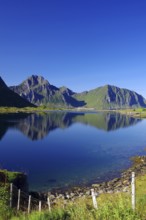 Mountains reflected in the calm waters of an inlet, Leknes, Vestvågøy, Lofoten, Nordland, Norway,