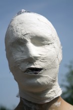 Model released young man's face covered in white bandage tape as art project