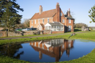 Traditional red brick farmhouse and farmyard water pond, Lux Farm, Kesgrave, Suffolk, England,